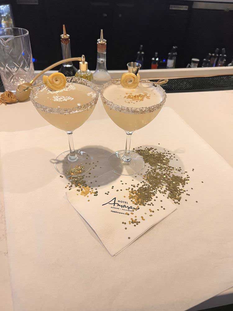 Close-up of two aesthetically plated drinks with garnishes, set against the backdrop of Hotel Amarano
