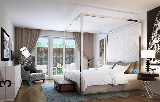 Elegant hotel guest room featuring a king-sized canopy bed, modern furnishings, patterned armchair, and French doors opening to a private patio.